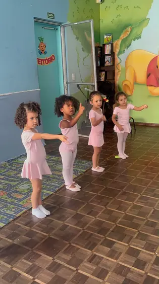 Turma em pé, com os bracinhos na posição do balé