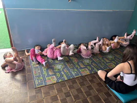 Turma deitada no colchonete fazendo o exercício de perninhas
