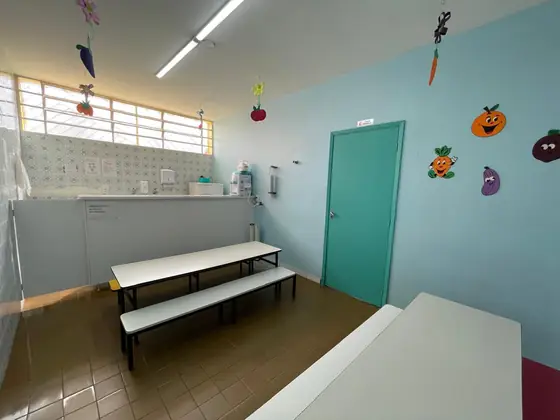 O refeitório, com as mesas e a bancada de apoio ao fundo