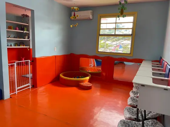 Prateleiras, mesa de atividades e espaço livre para brincar